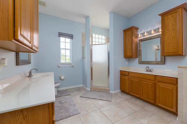 bathroom featuring tile patterned flooring, vanity, toilet, and walk in shower