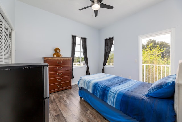 bedroom with ceiling fan, access to exterior, stainless steel fridge, and dark hardwood / wood-style flooring