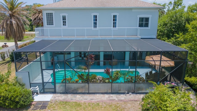 rear view of house featuring a lanai, a patio, and a balcony