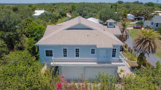 back of property with a garage and a balcony