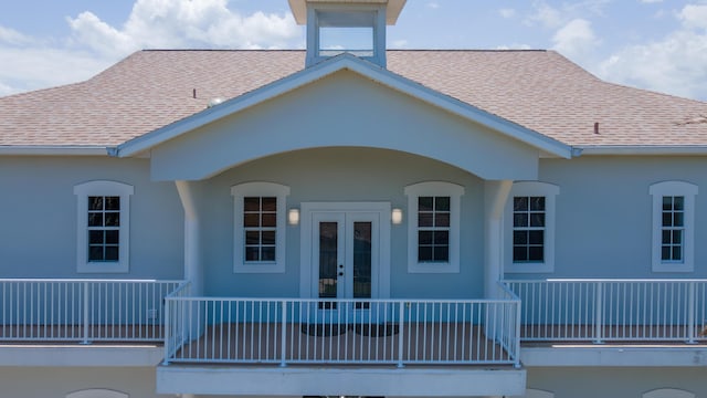 rear view of property featuring a porch and french doors