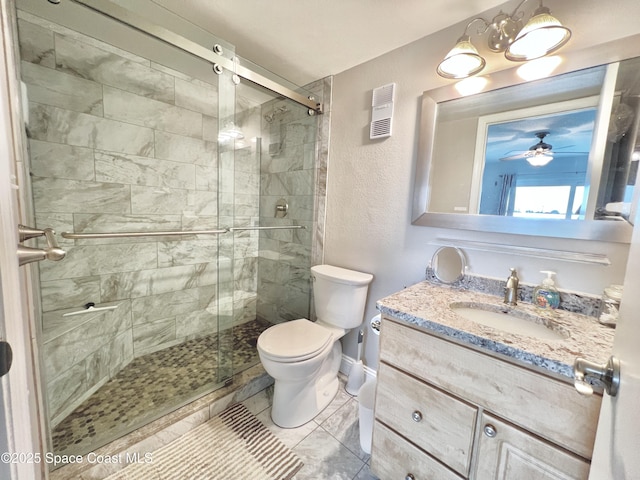 bathroom featuring a shower with door, vanity, tile patterned floors, and toilet