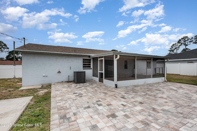 rear view of property with central AC, a sunroom, and a patio