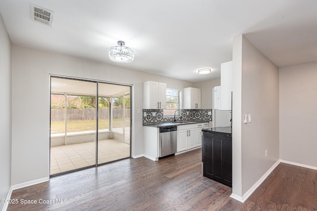 kitchen with white cabinetry, stainless steel dishwasher, dark hardwood / wood-style flooring, and backsplash