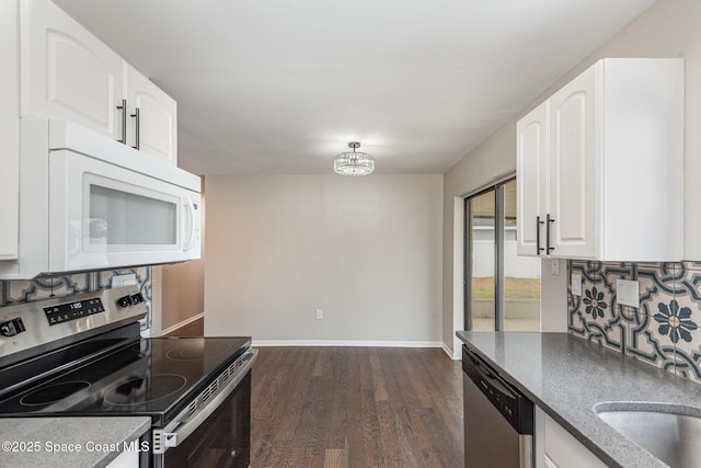 kitchen with dark hardwood / wood-style floors, white cabinetry, sink, backsplash, and stainless steel appliances