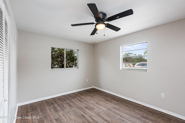 spare room with dark wood-type flooring, ceiling fan, and plenty of natural light