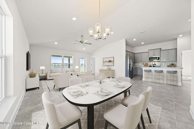 dining room with lofted ceiling and ceiling fan with notable chandelier