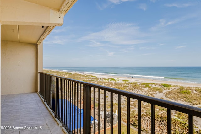 balcony featuring a water view and a beach view