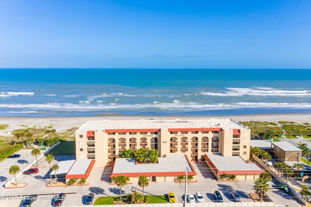 bird's eye view with a water view and a beach view