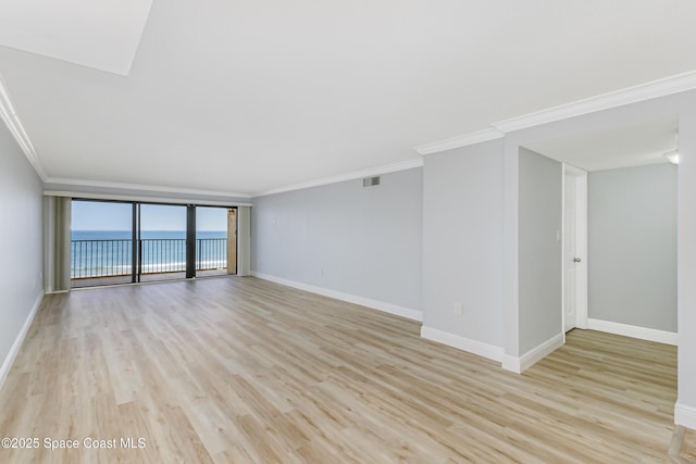 spare room featuring a water view, crown molding, and light wood-type flooring