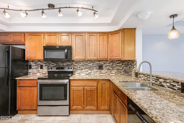 kitchen featuring sink, light stone counters, tasteful backsplash, black appliances, and decorative light fixtures