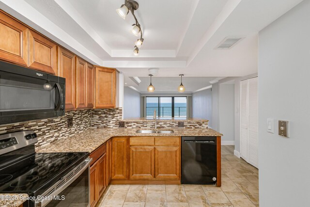 kitchen featuring sink, kitchen peninsula, a raised ceiling, pendant lighting, and black appliances