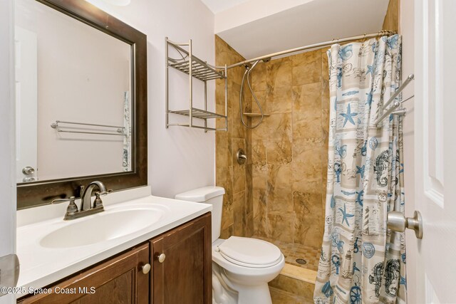 bathroom featuring vanity, toilet, and curtained shower