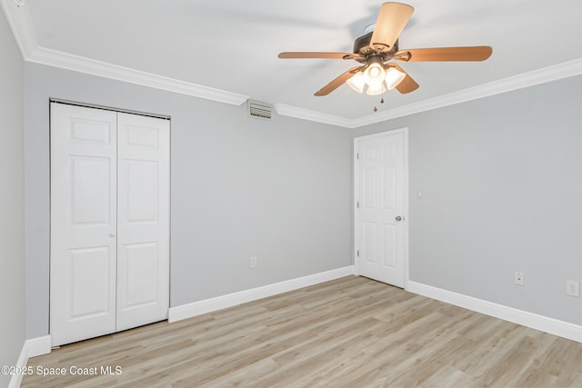 unfurnished bedroom with a closet, ornamental molding, light hardwood / wood-style floors, and ceiling fan