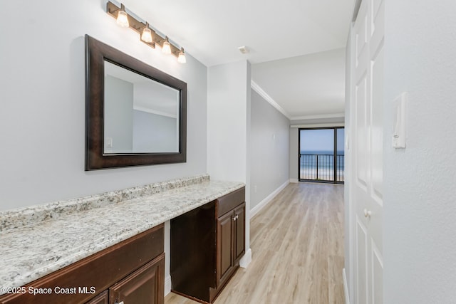 bathroom with ornamental molding, hardwood / wood-style floors, and vanity