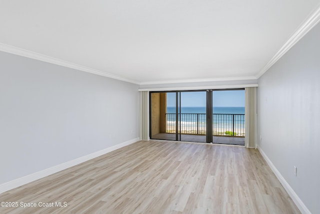 unfurnished room with a water view, crown molding, and light hardwood / wood-style flooring