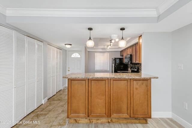 kitchen featuring light stone countertops, kitchen peninsula, backsplash, and black appliances