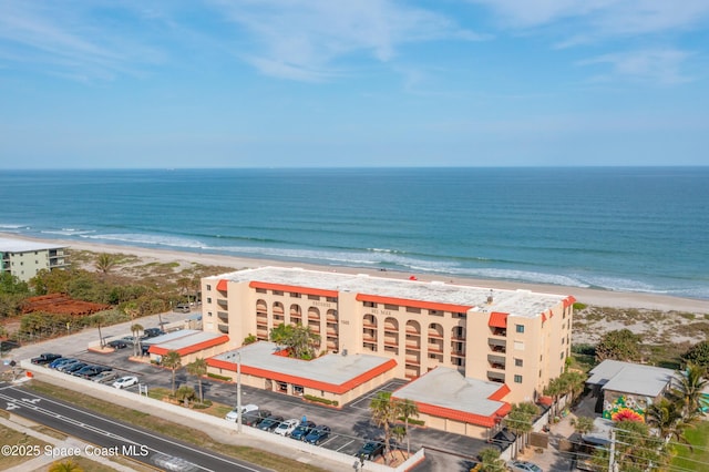 drone / aerial view featuring a water view and a view of the beach