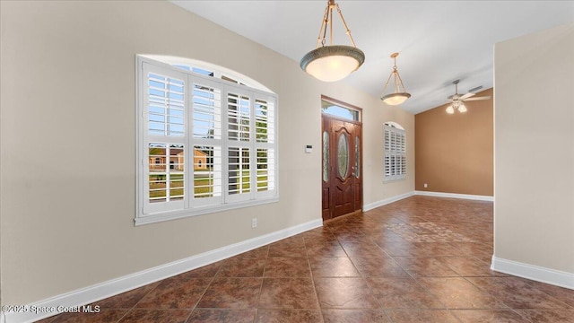 foyer entrance featuring baseboards, vaulted ceiling, and a ceiling fan