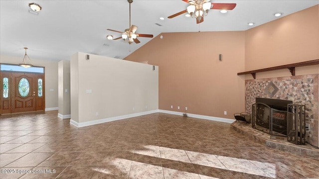 unfurnished living room with high vaulted ceiling, a stone fireplace, tile patterned floors, and baseboards