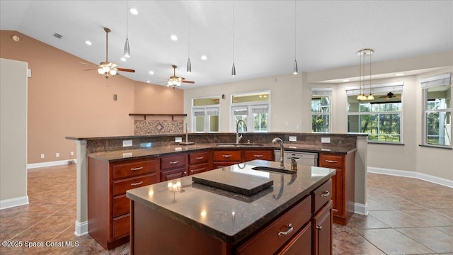 kitchen with a sink, visible vents, vaulted ceiling, a large island, and decorative backsplash