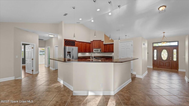 kitchen with light tile patterned floors, visible vents, dark countertops, appliances with stainless steel finishes, and a large island with sink