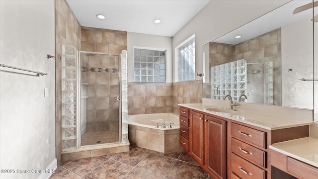 bathroom with a stall shower, tile patterned flooring, vanity, and a bath