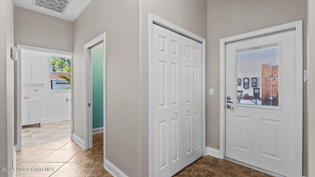 tiled entryway with visible vents and baseboards