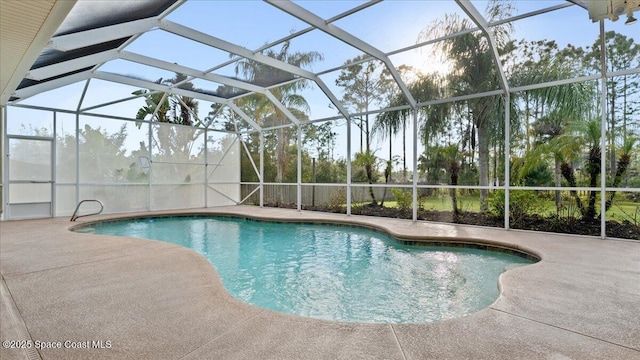 pool with glass enclosure and a patio