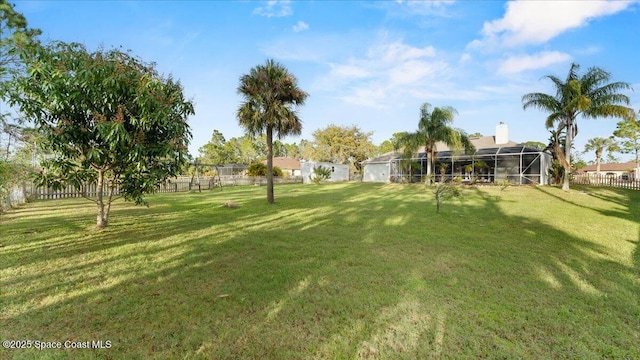 view of yard featuring a lanai and fence