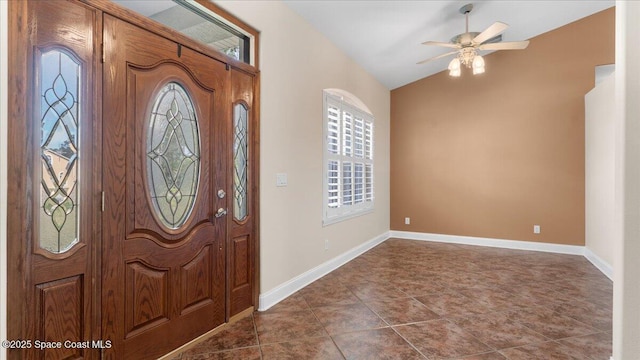 foyer entrance featuring lofted ceiling, dark tile patterned flooring, ceiling fan, and baseboards