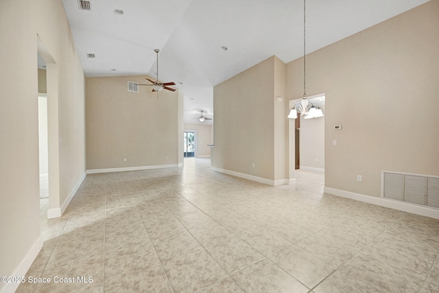 empty room with ceiling fan with notable chandelier, tile patterned floors, and high vaulted ceiling