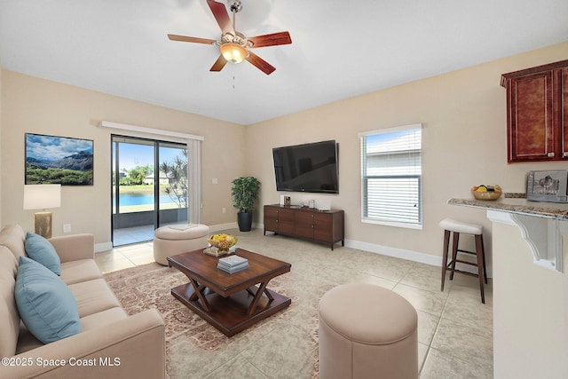 tiled living room featuring plenty of natural light and ceiling fan