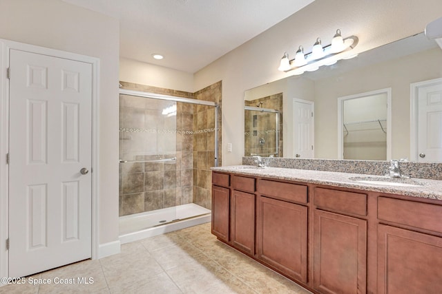 bathroom with an enclosed shower, vanity, and tile patterned flooring