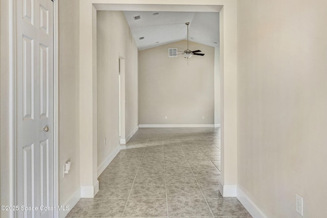 hall featuring lofted ceiling and light tile patterned floors