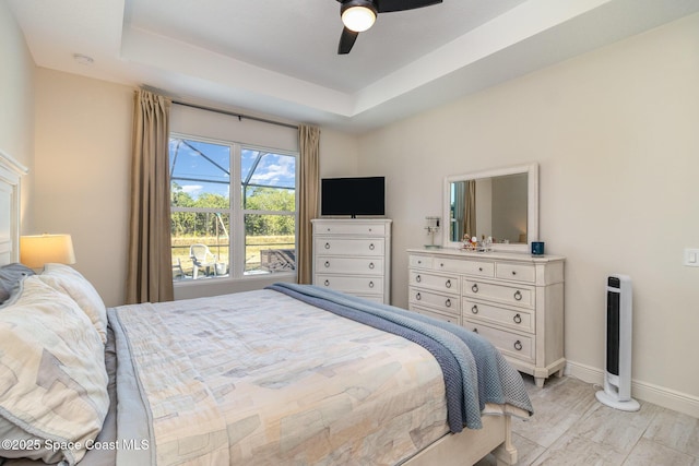 bedroom featuring a raised ceiling and ceiling fan