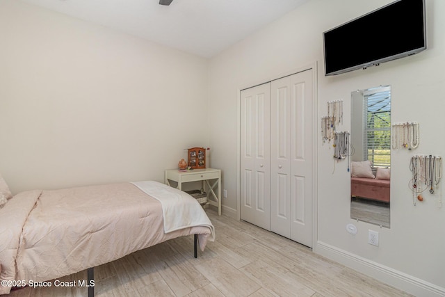 bedroom with ceiling fan, a closet, and light wood-type flooring