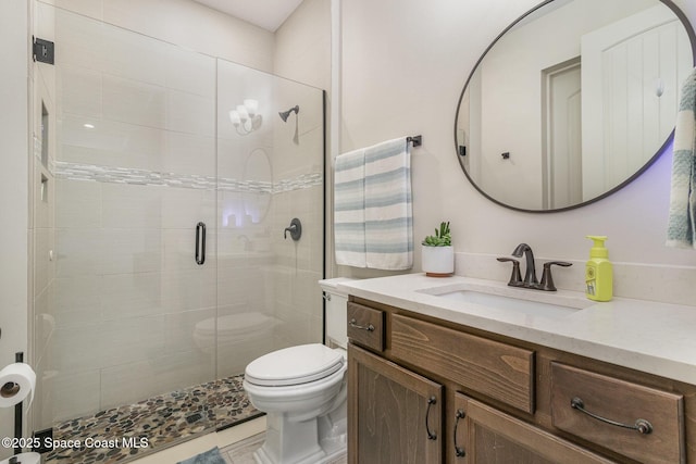 bathroom with walk in shower, vanity, and toilet