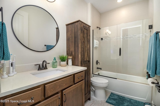 full bathroom featuring vanity, enclosed tub / shower combo, and toilet