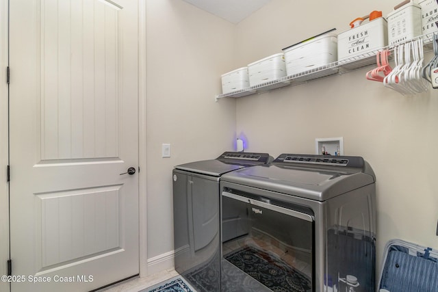 laundry room featuring washer and clothes dryer and tile patterned floors