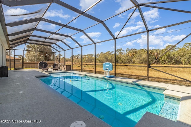 view of pool with glass enclosure and a patio area