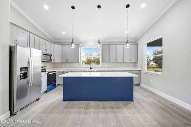 kitchen with a center island, vaulted ceiling, ornamental molding, appliances with stainless steel finishes, and pendant lighting