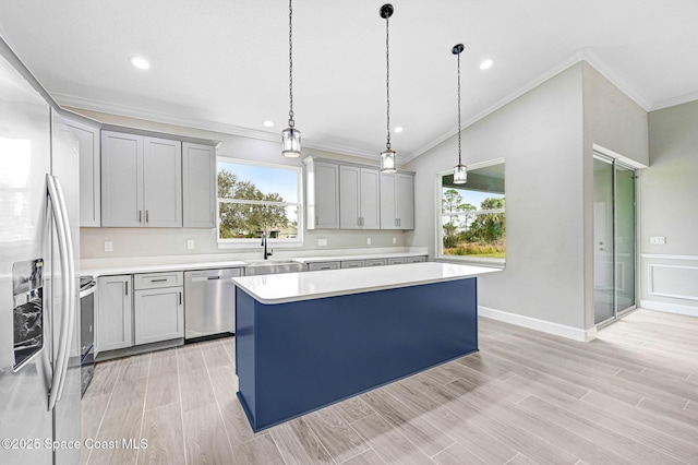 kitchen featuring sink, decorative light fixtures, a center island, and appliances with stainless steel finishes