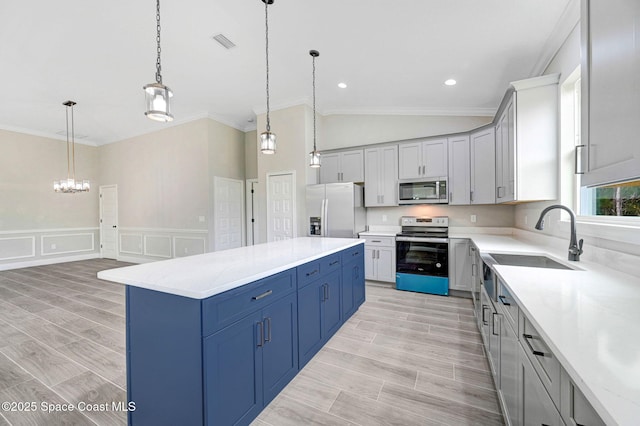 kitchen featuring pendant lighting, appliances with stainless steel finishes, crown molding, and a kitchen island