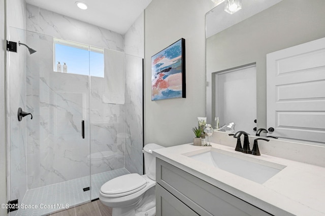 full bath featuring toilet, a marble finish shower, and vanity