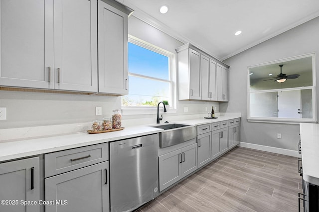 kitchen featuring a sink, ornamental molding, stainless steel dishwasher, and gray cabinetry