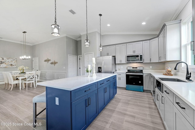 kitchen with crown molding, stainless steel appliances, light countertops, visible vents, and a sink