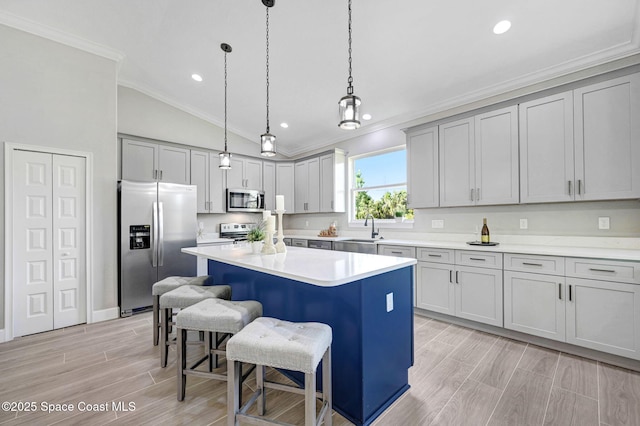 kitchen featuring a center island, crown molding, stainless steel appliances, a sink, and a kitchen breakfast bar