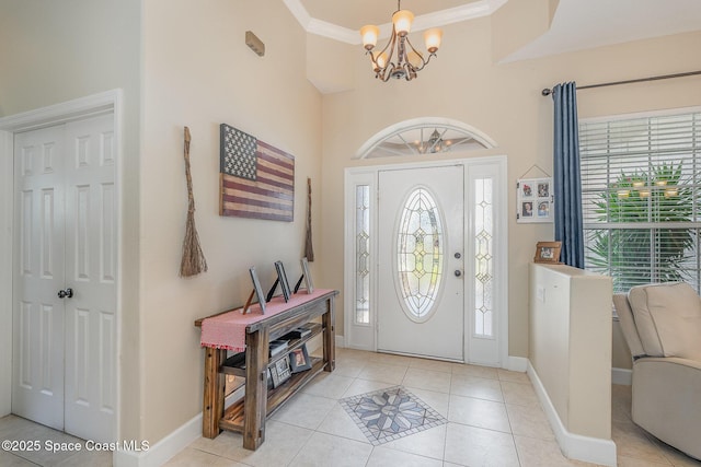 foyer entrance featuring ornamental molding, a wealth of natural light, a chandelier, and light tile patterned flooring