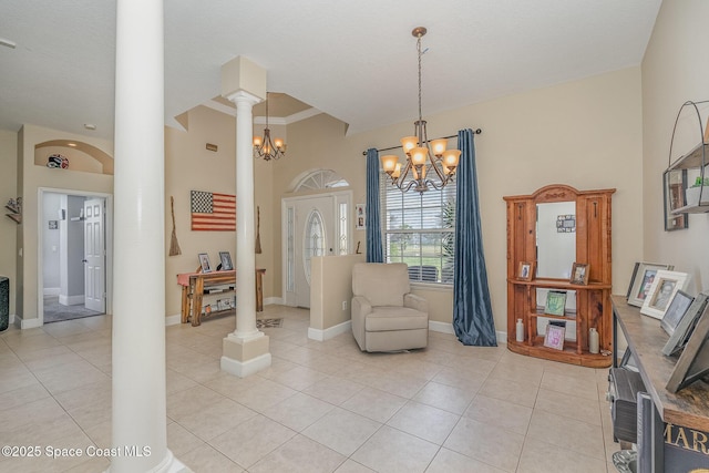 living area featuring ornate columns, crown molding, light tile patterned floors, and a chandelier